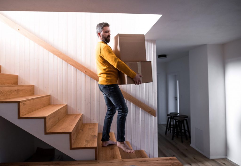 man walking down stairs in house holding m 2022 02 02 04 51 11 utc