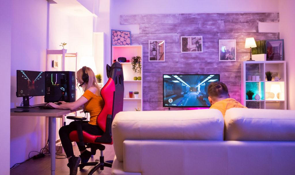 friends playing video games in a room with neon li 2022 05 26 21 17 59 utc