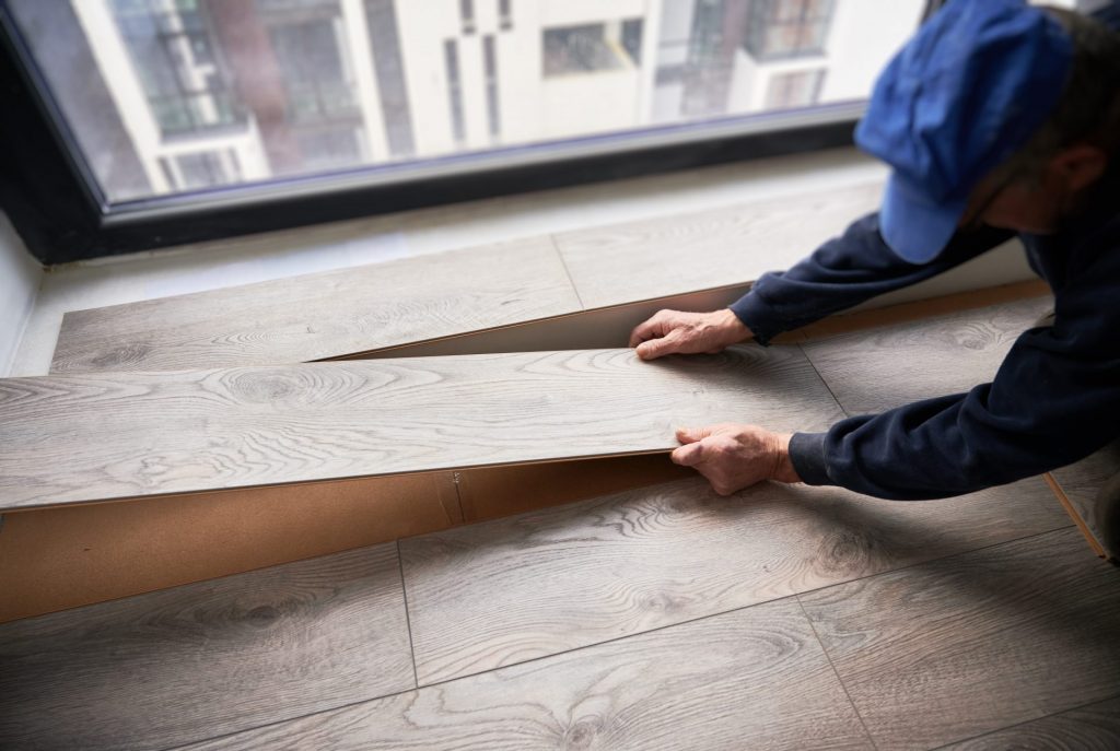 man laying laminate flooring in apartment under re 2023 04 03 19 24 49 utc
